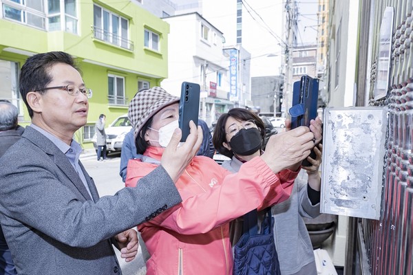 영등포구(구청장 최호권)가 올해 4월부터 서울시 최초로 건물번호판에 QR코드를 활용한 ‘재난·안전시설물 위치정보 제공 서비스’를 실시한다고 밝혔다. 최호권 구청장이 QR코드 건물번호판을 스캔하는 모습 (사진=영등포구청)