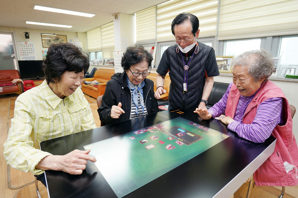 답십리3동경로당을 이용하는 어르신들이 스마트 테이블을 활용해 치매예방 게임을 즐기고 있다. (사진=동대문구청)