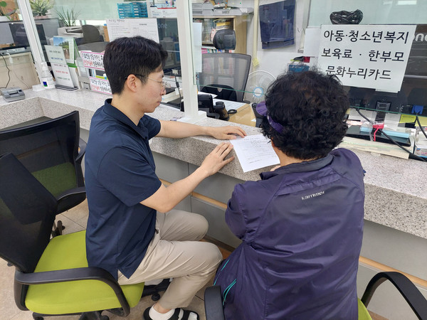 도봉구민이 동주민센터 직원의 도움을 받아 위기가구 발견 신고서를 작성하고 있다. (사진=도봉구청)
