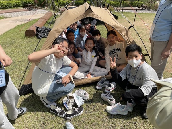 강북구가 운영하는 초등학생 일일캠핑체험 제1회 우리마을 강북여행에 참여한 번동초등학교 5학년 학생들이 텐트를 함께 치며 협동심을 길렀다. (사진=강북구청)