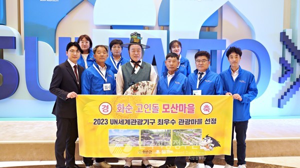 우즈베키스탄에서 열린 제25차 유엔 세계관광기구 총회에서 화순군 모산마을이 제3회 UNWTO 선정 최우수 관광마을로 선정되었다. 사진은 홍기연 모산마을 주민대표(중앙 우측, 맨앞 우측 3번째)와 구복규 화순군수(중앙 좌측, 한복차림)를 비롯한 화순군 대표단이 기념 촬영을 하고있다(사진=화순군청/사마르칸트)