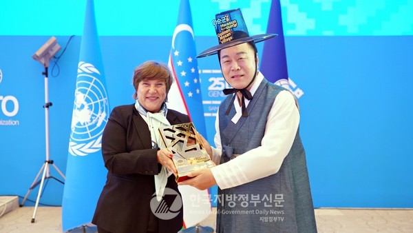 구복규 화순군수(오른쪽)가 UN 세계관광기구로부터 세계 최우수 관광마을 인증서를 받고있다(사진=화순군청/사마르칸트)