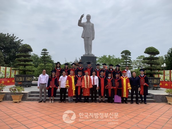 응우옌띠엔루언 응우옌짜이대학교 이사장(앞줄 왼쪽 여섯번째)과 안경환 대외총장(앞줄 왼쪽 네번째)이 대학원 석사학위 취득자 18명과 함께 학위 수여식 후 꼬또현 청사 맞은편에 위치한 국가유적지로 지정된 호찌민 사당 석상 앞에서 기념사진을 찍고 있다(사진=안경환)